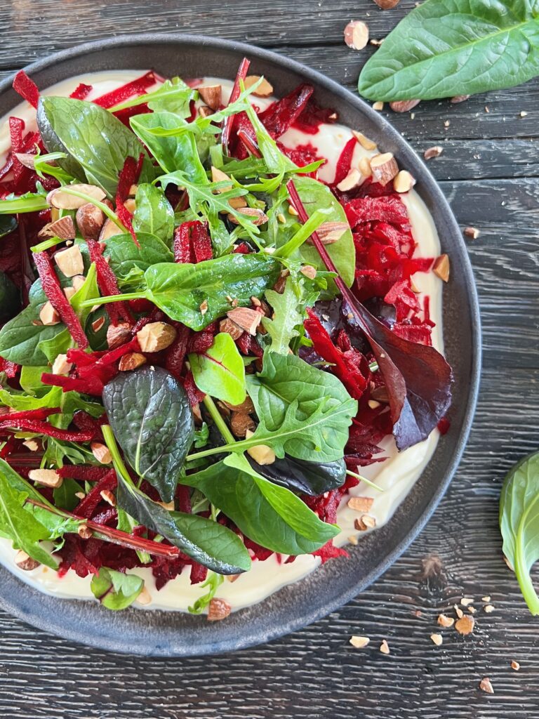 salat-med-revet-raa-roedbeder-lagt-paa-bund-af-yoghurt-med-hvidloeg-set-taet-paa
