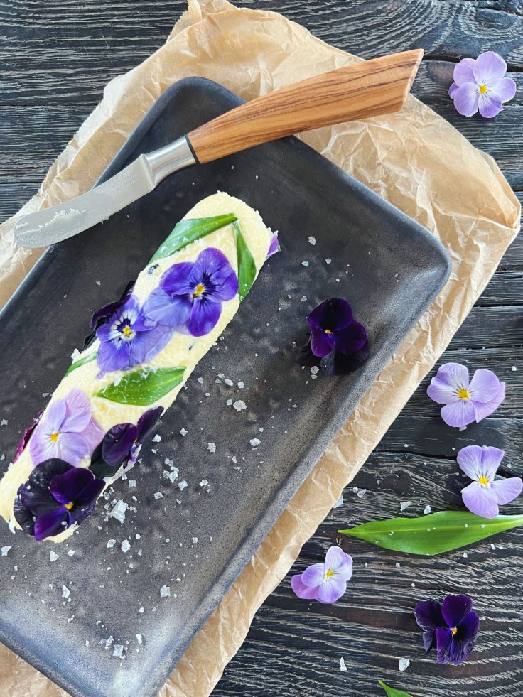 blomstersmør en rulle smør er pyntet med spiselige blomster